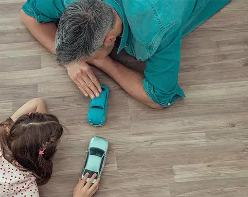 Kid with father playing with toy cars | Myers Flooring of Nashville